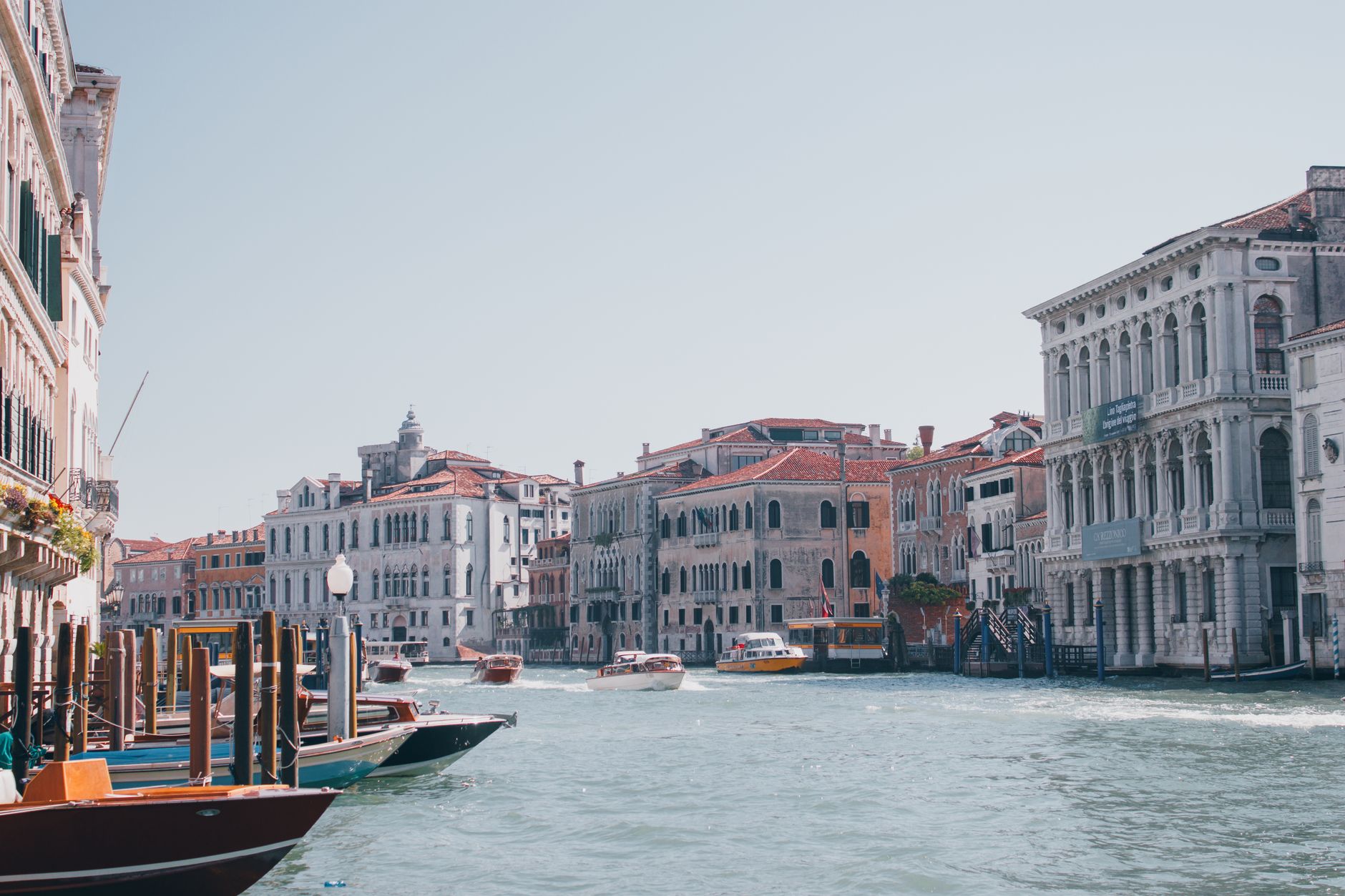 Discover the beauty of Venice's Grand Canal lined with historic buildings and boats under clear skies