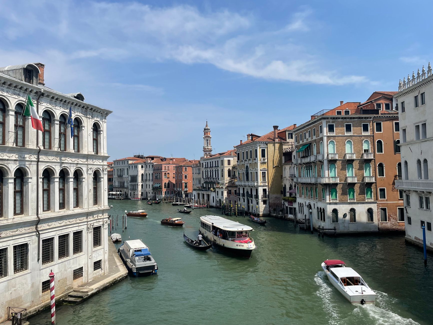 Venice's Grand Canal with historic buildings and water traffic under a blue sky