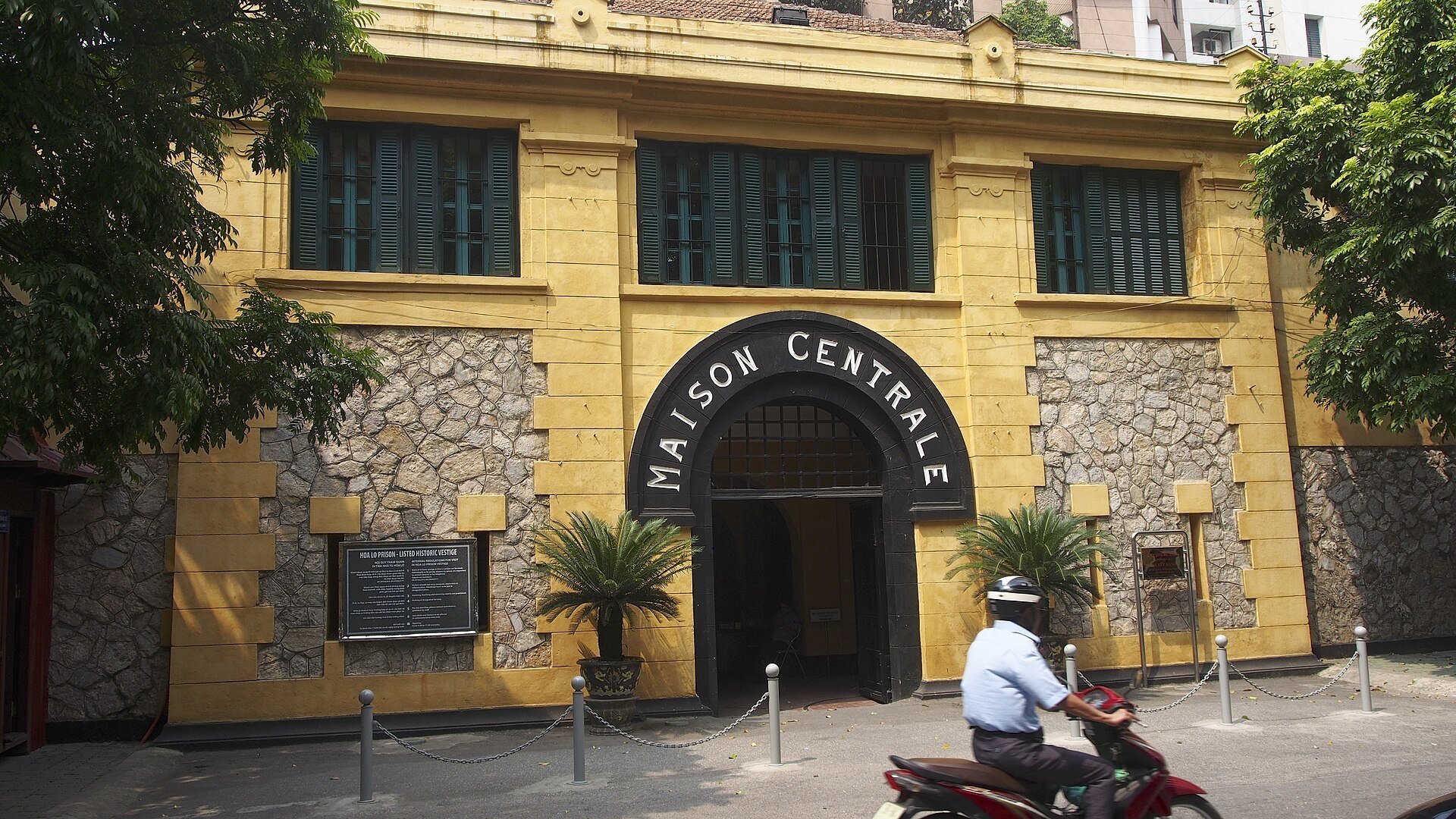 The yellow façade of Hoa Lo Prison with MAISON CENTRALE lettered above the gate