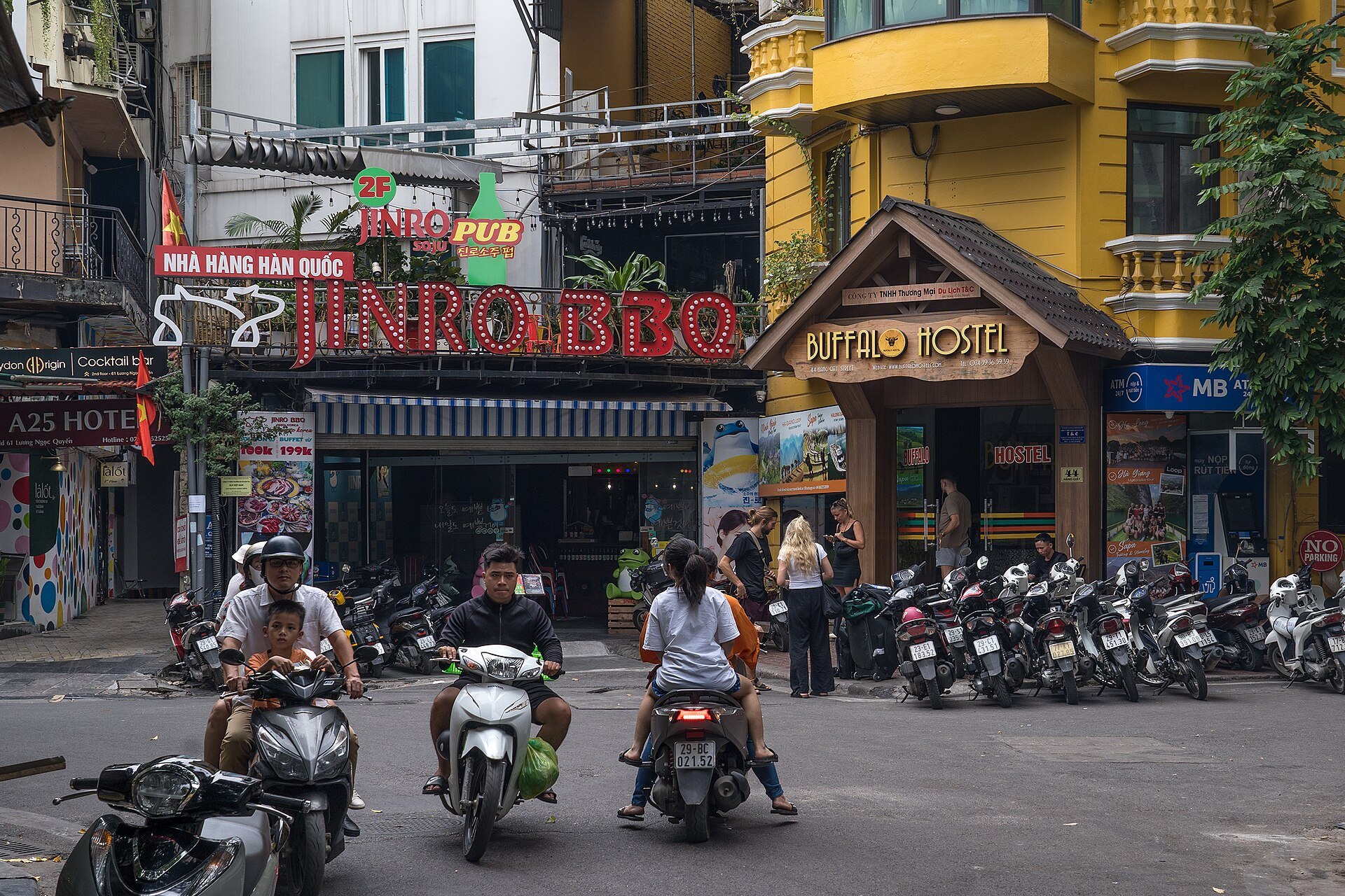 Motorbikes filling an Old Quarter junction between ochre shophouses