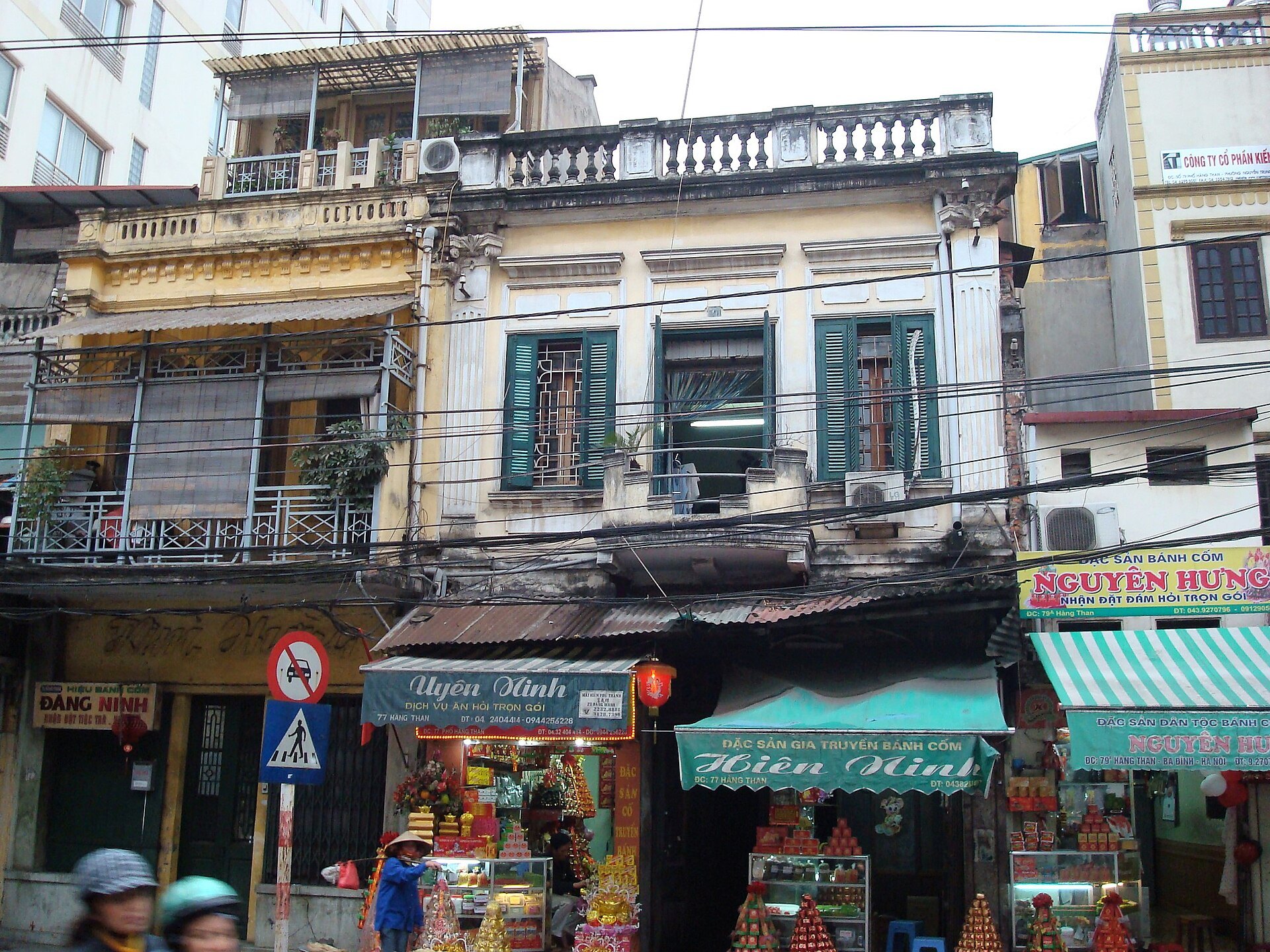 Shopfronts and hanging goods along an Old Quarter street